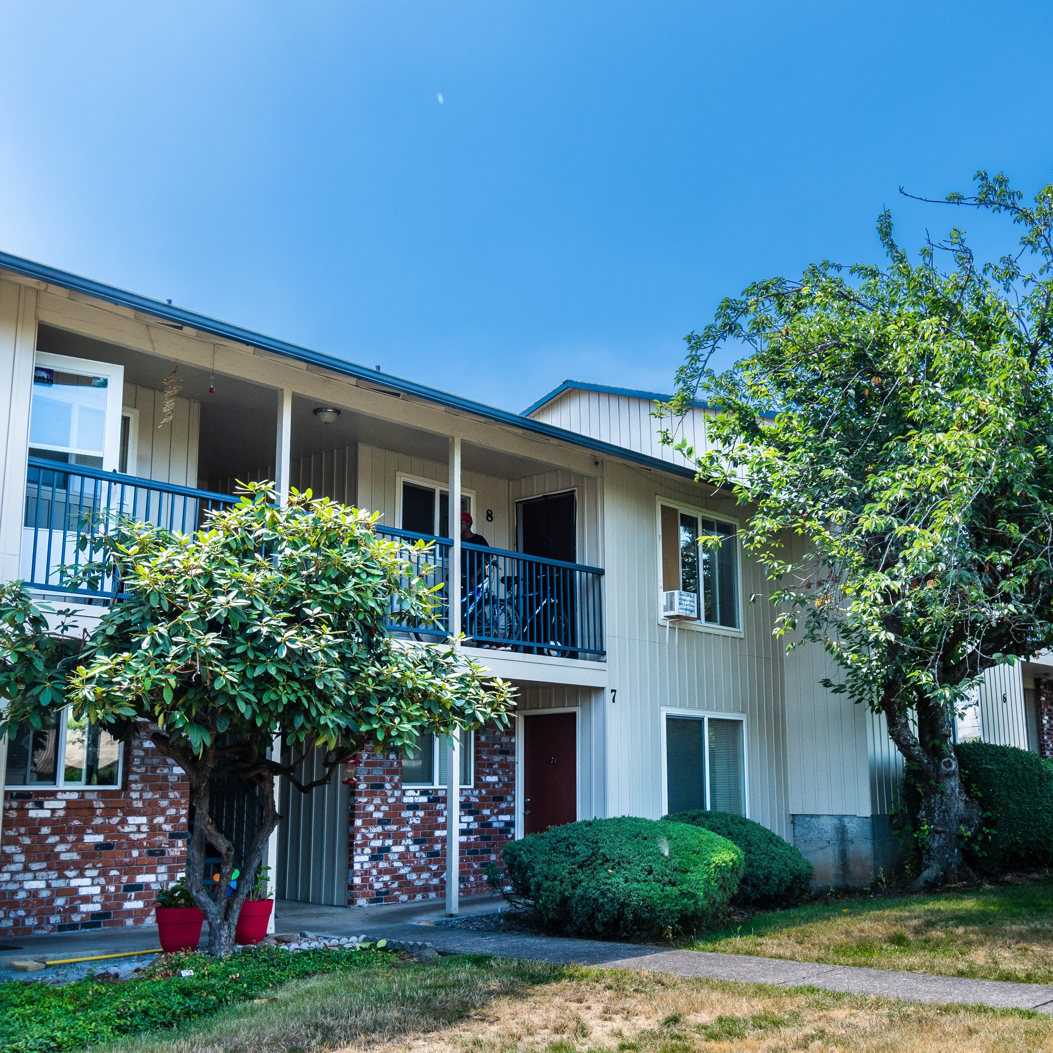 an apartment building with two trees in front of it