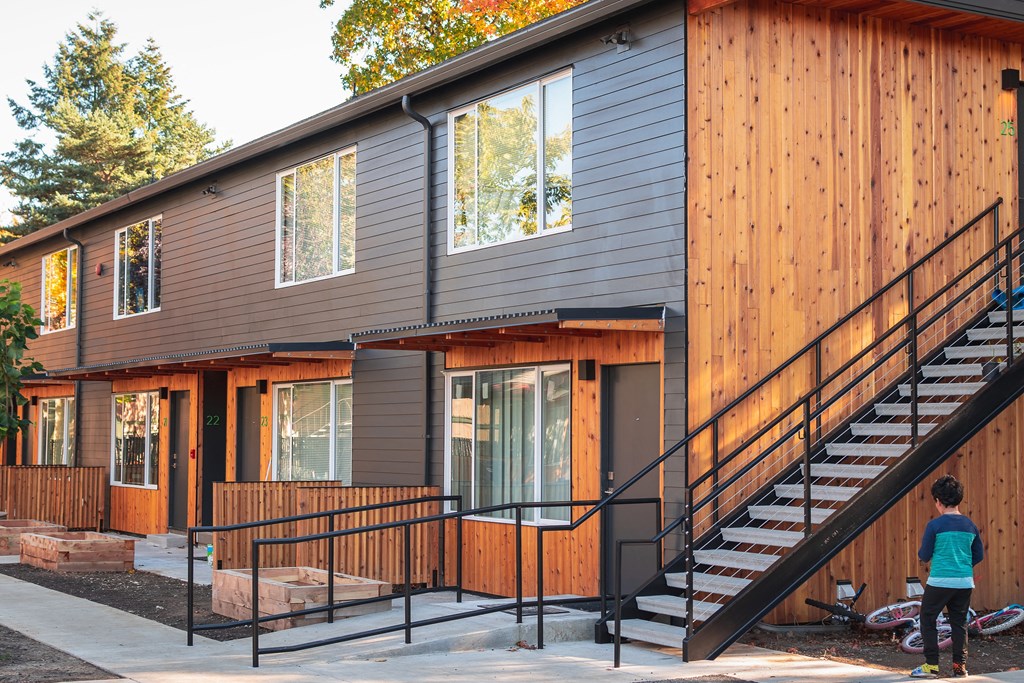 a modular home with a staircase and a porch in front of it