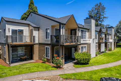 A row of townhouses with balconies and front yards.