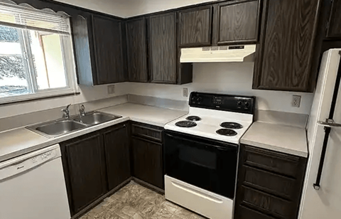 A kitchen with a white stove and black oven.