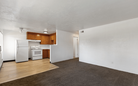 A kitchen with white appliances and wooden cabinets is visible.