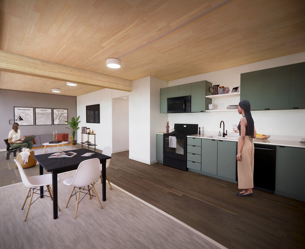 A woman is standing in a kitchen with a table and chairs.