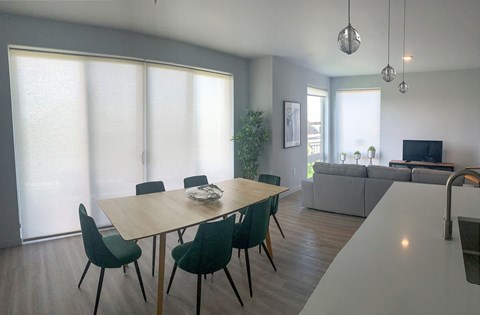 a dining room with a wooden table and green chairs