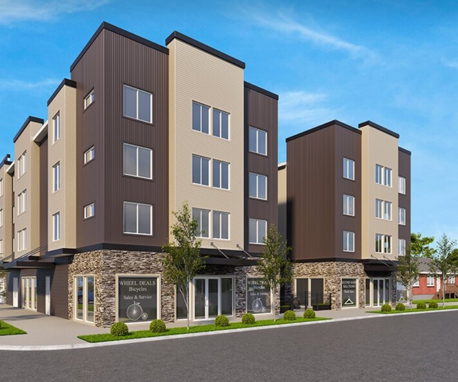 A modern apartment building with a sign for Wheel Deal Bicycles in front.