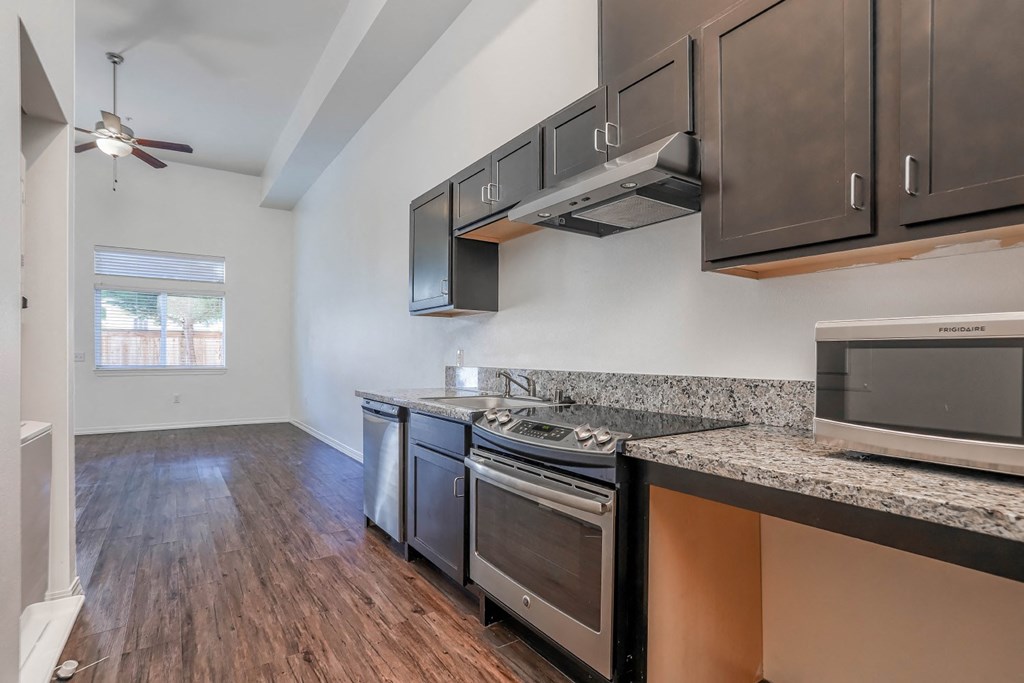 a kitchen with granite countertops and stainless steel appliances