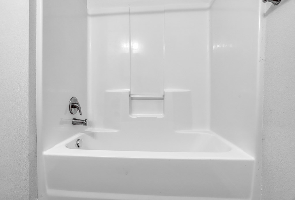 a white bathtub with a silver faucet