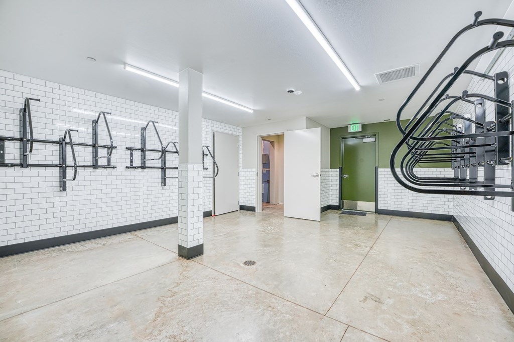 A clean, empty gym with white walls and black equipment.