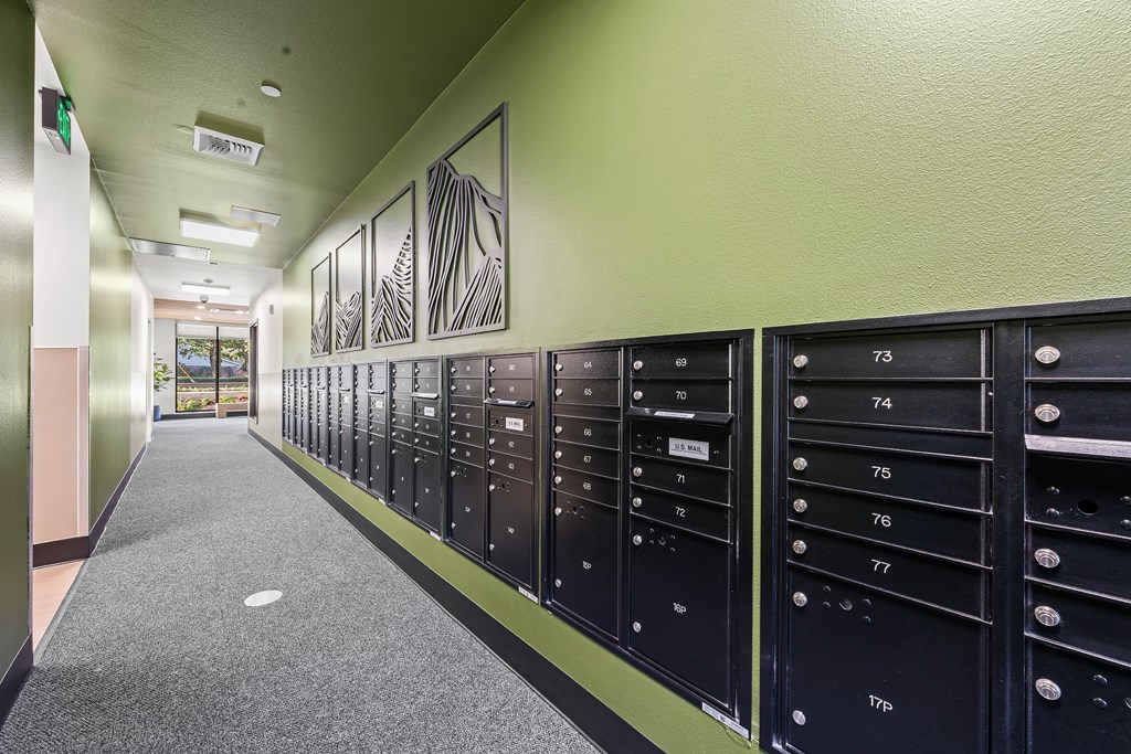A long hallway with a series of mailboxes on the wall.