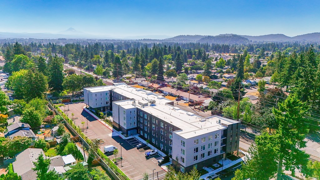 A large white building with a parking lot in front of it.