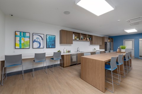 A kitchen with a table and chairs and a painting on the wall.