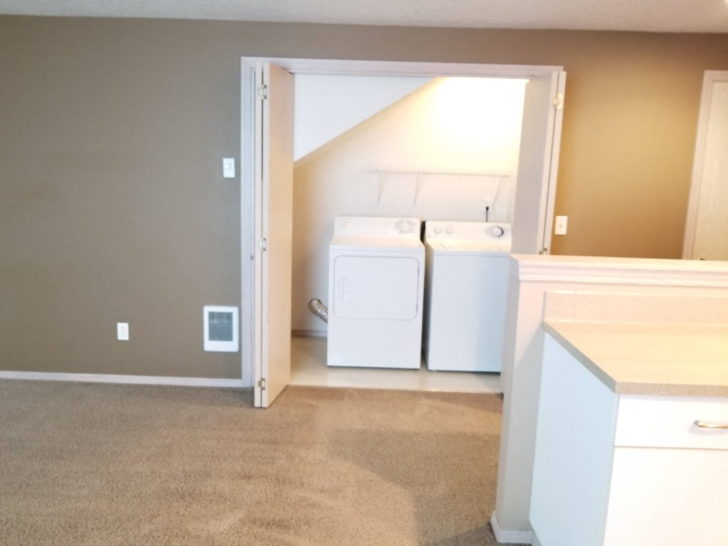 an empty laundry room with washer and dryer in it