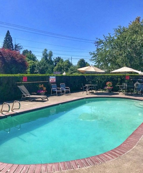 a swimming pool with umbrellas and chairs around it