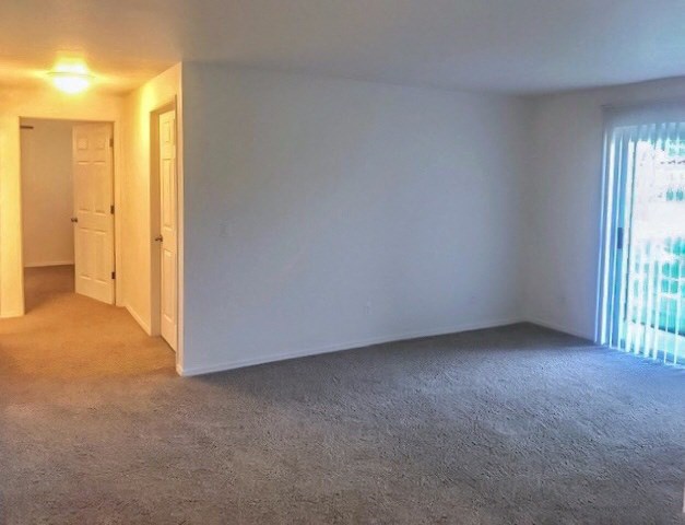 an empty living room with a window and a door