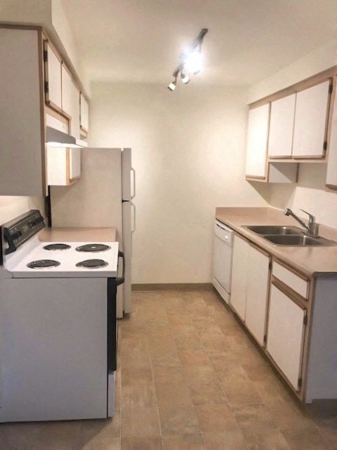 an empty kitchen with a stove and a sink