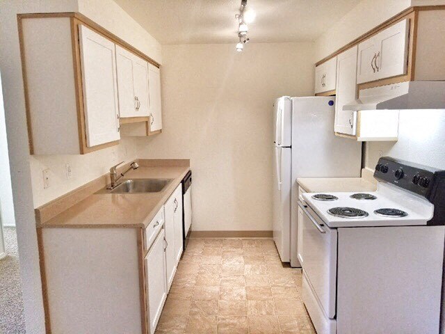 a kitchen with a stove refrigerator and sink