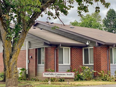 an old brick house with a sign in front of it