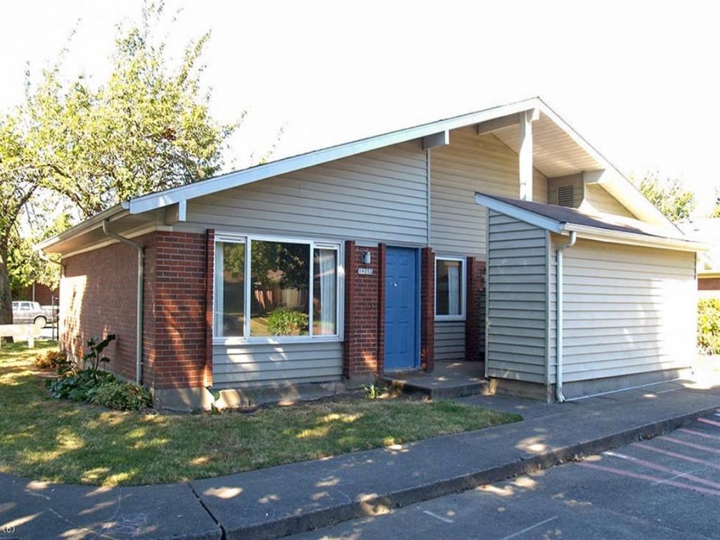 a small house with a blue door and a lawn
