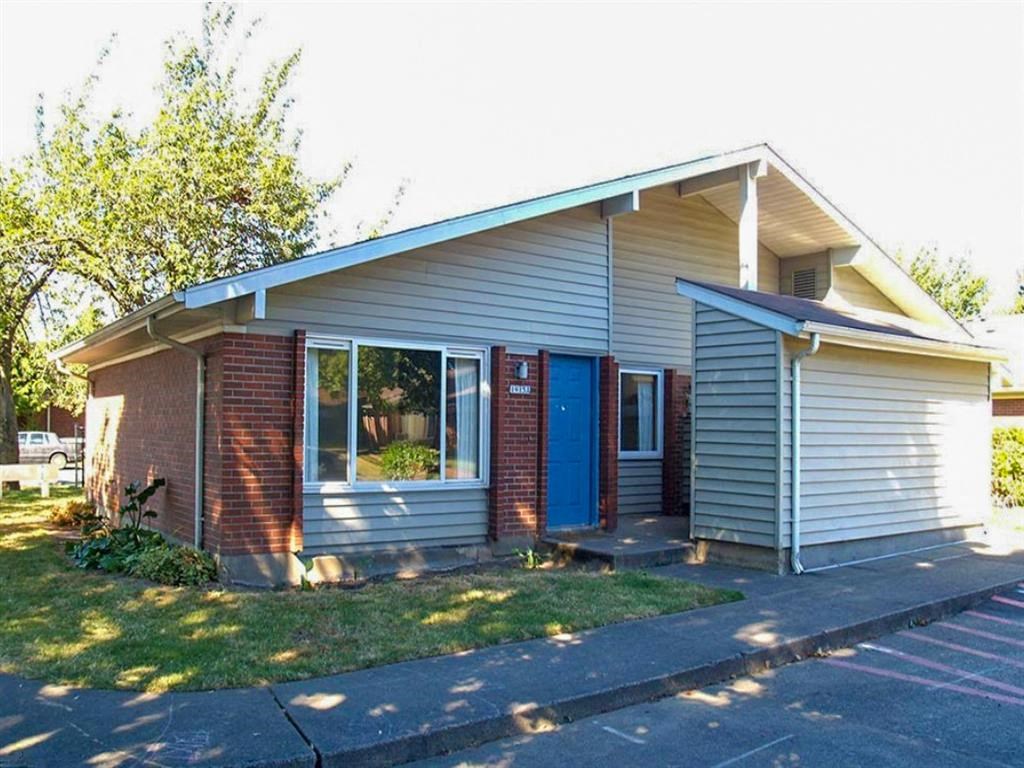a small house with a blue door and a lawn
