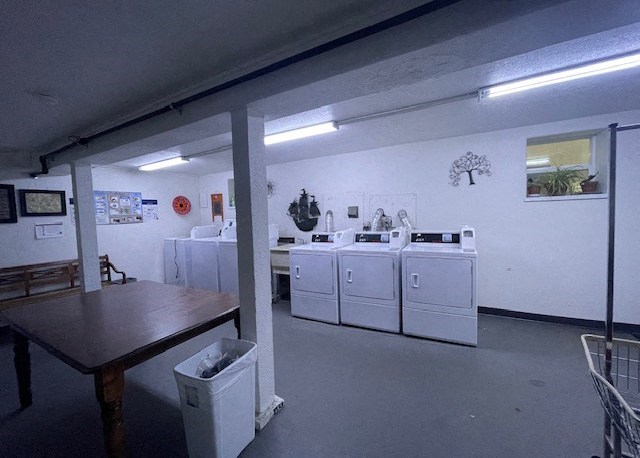 a laundry room with washing machines and a table