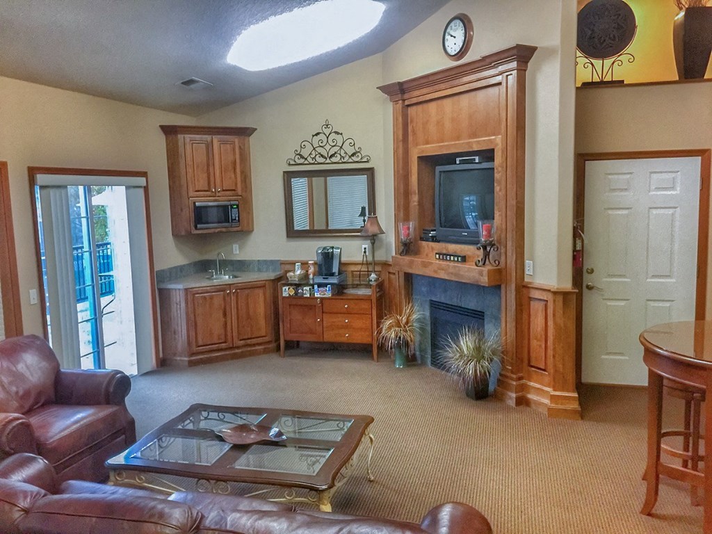 a living room with a fireplace and a kitchen