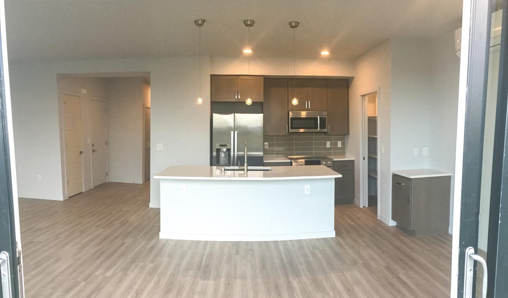 an open kitchen and living room with a white counter top