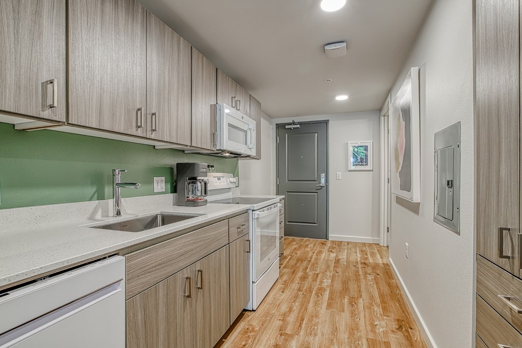A kitchen with wooden cabinets and a green backsplash.