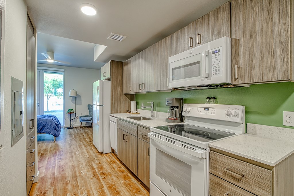 A kitchen with white appliances and wooden cabinets.