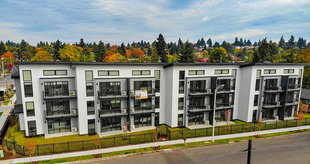 an aerial view of an apartment building with trees in the background