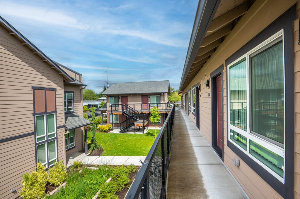 the view from the balcony of a home with a long walkway
