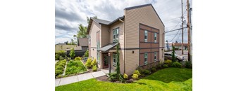 the front of a house with a sidewalk and grass