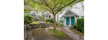 the front yard of a house with a tree in front of it