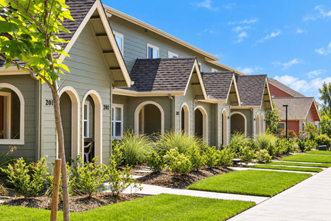 A row of houses with green exteriors and white trim.
