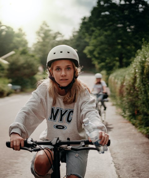 a young girl riding a bike down a street