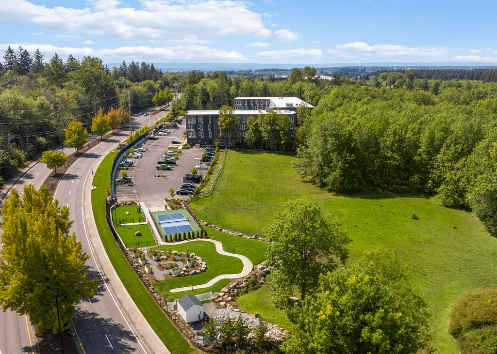an aerial view of a parking lot and a park with trees