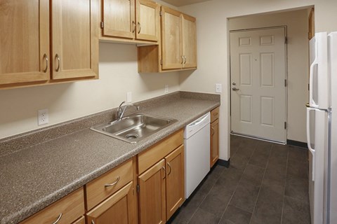 A kitchen with wooden cabinets and a white refrigerator.
