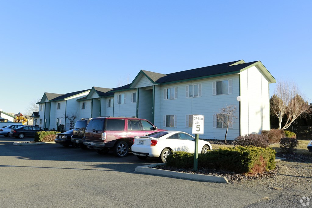 an apartment building with cars parked in front of it