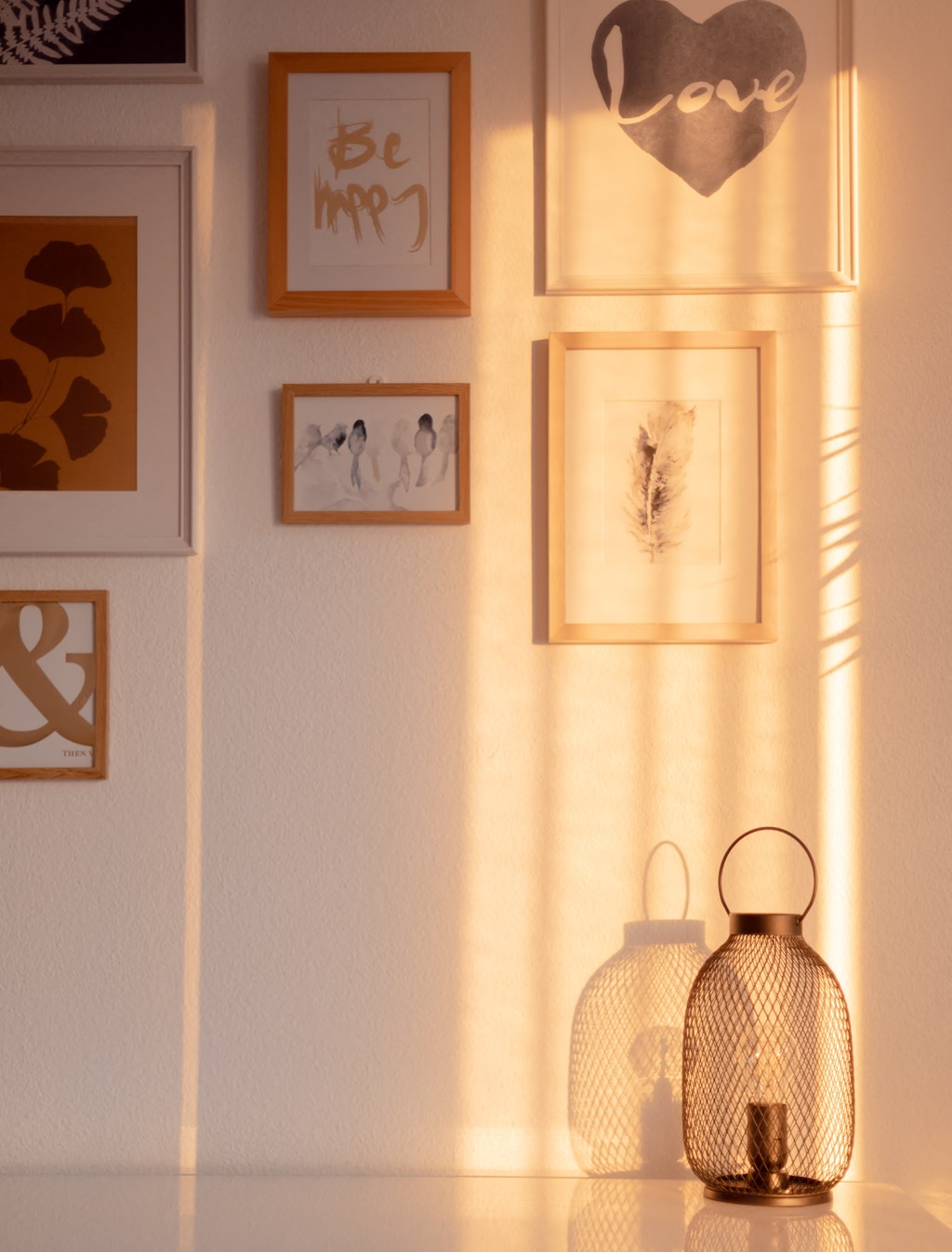 a shelf with two lanterns and pictures on the wall