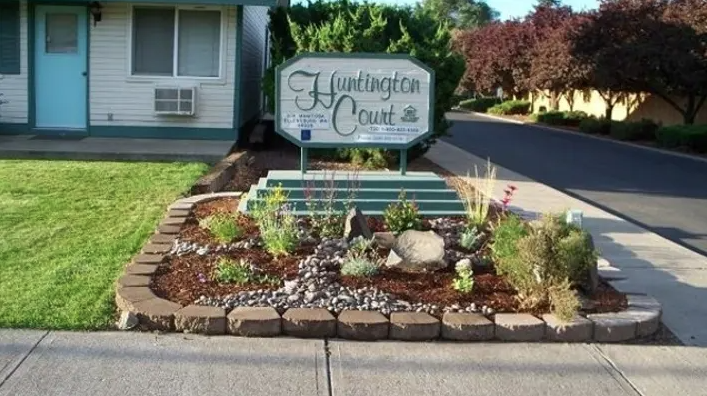 a landscaped front yard with a sign for the yukon court house