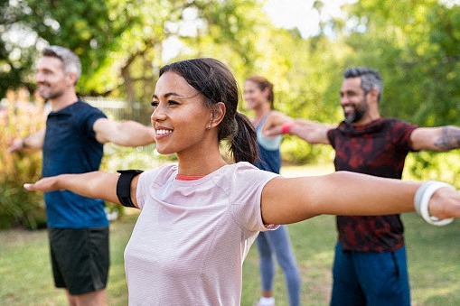a group of people exercising in a park