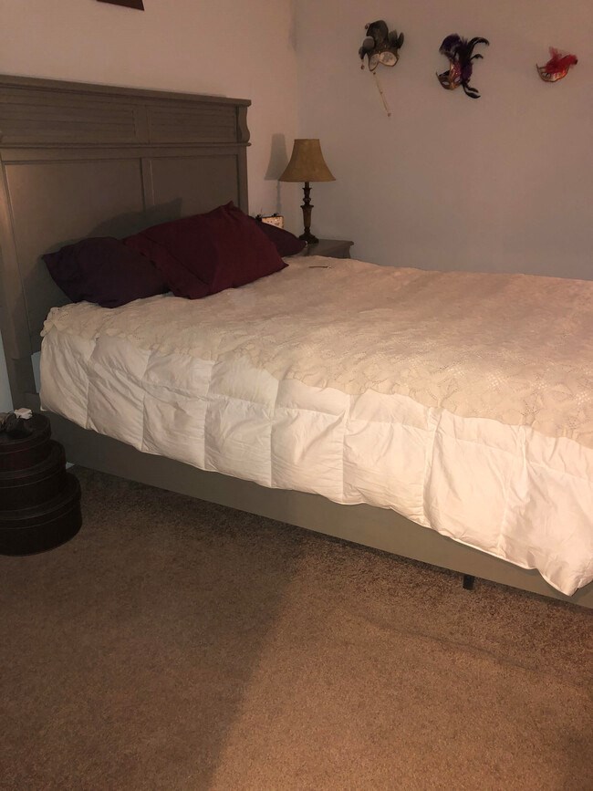 a bed with a white comforter and red pillows