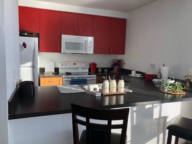 a kitchen with a black counter top and a white stove top oven