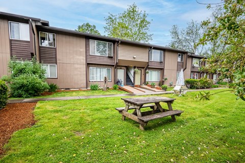 a picnic table in a yard in front of a building