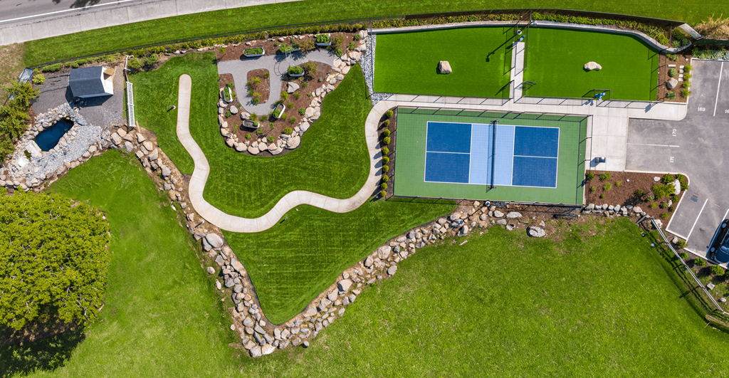 a birds eye view of a park with a yard and a tennis court