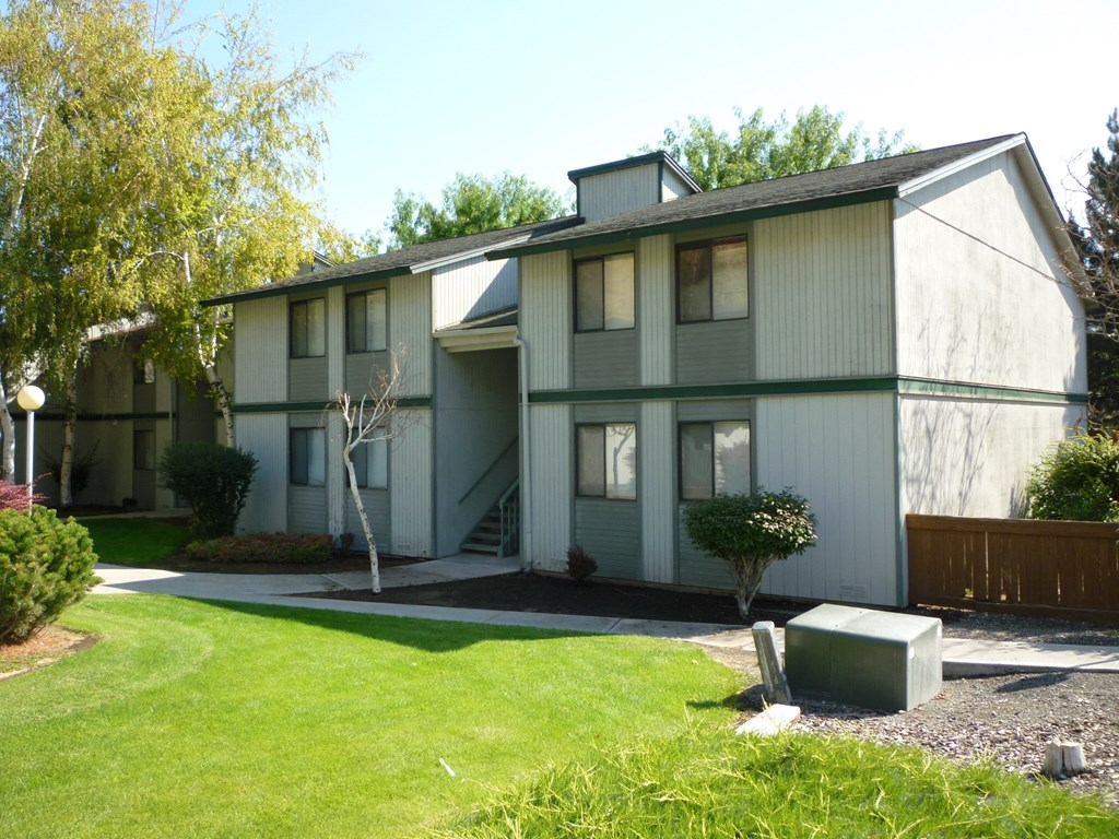 a gray and with a lawn and a driveway