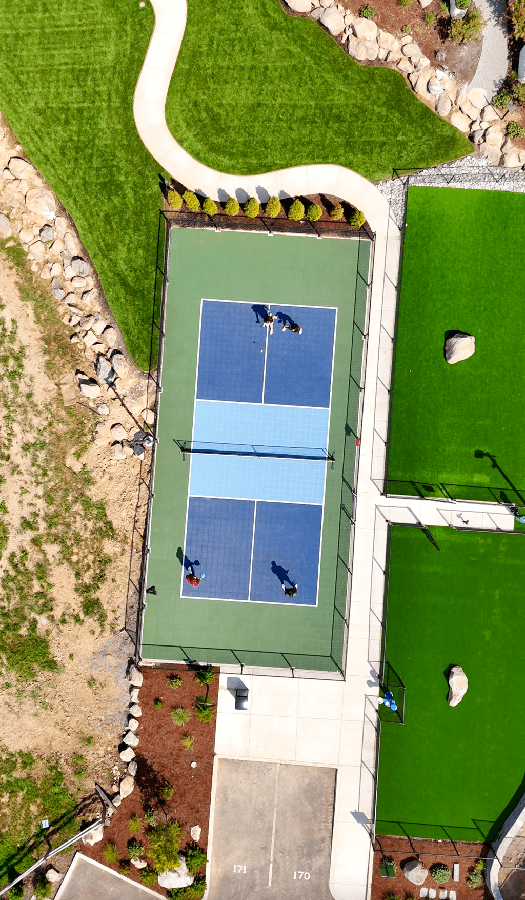 an aerial view of a tennis court on a green court