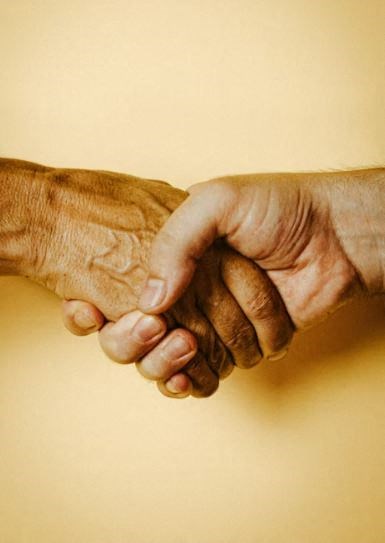 two hands clasped together and holding each other