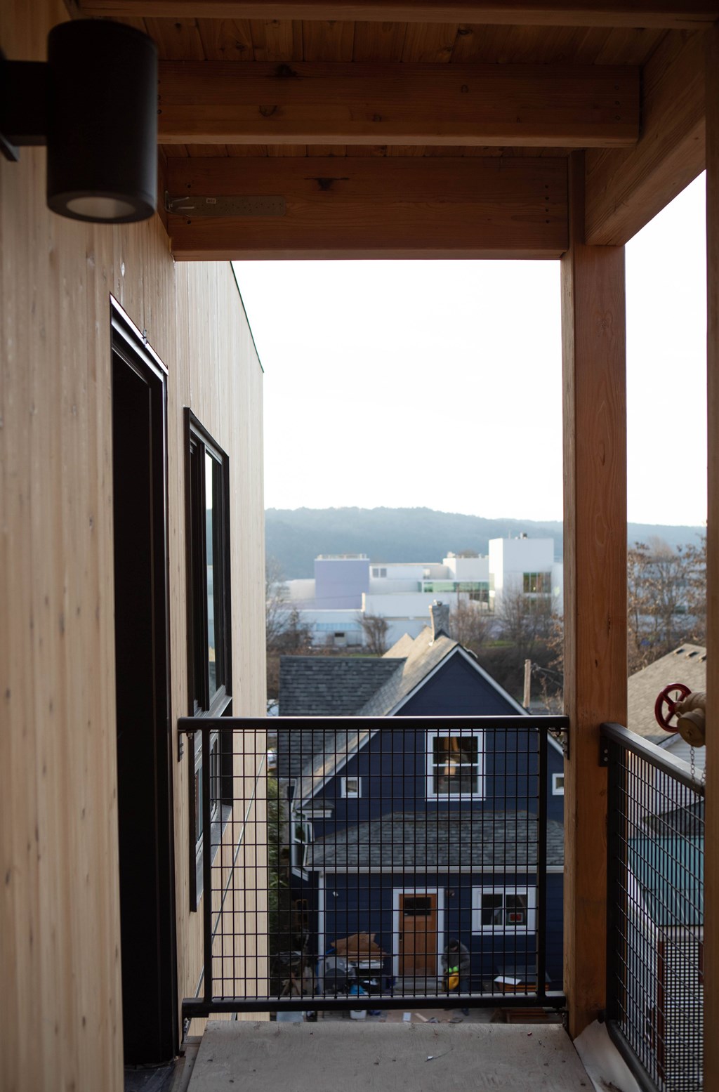 A view from a balcony looking out at a blue house.