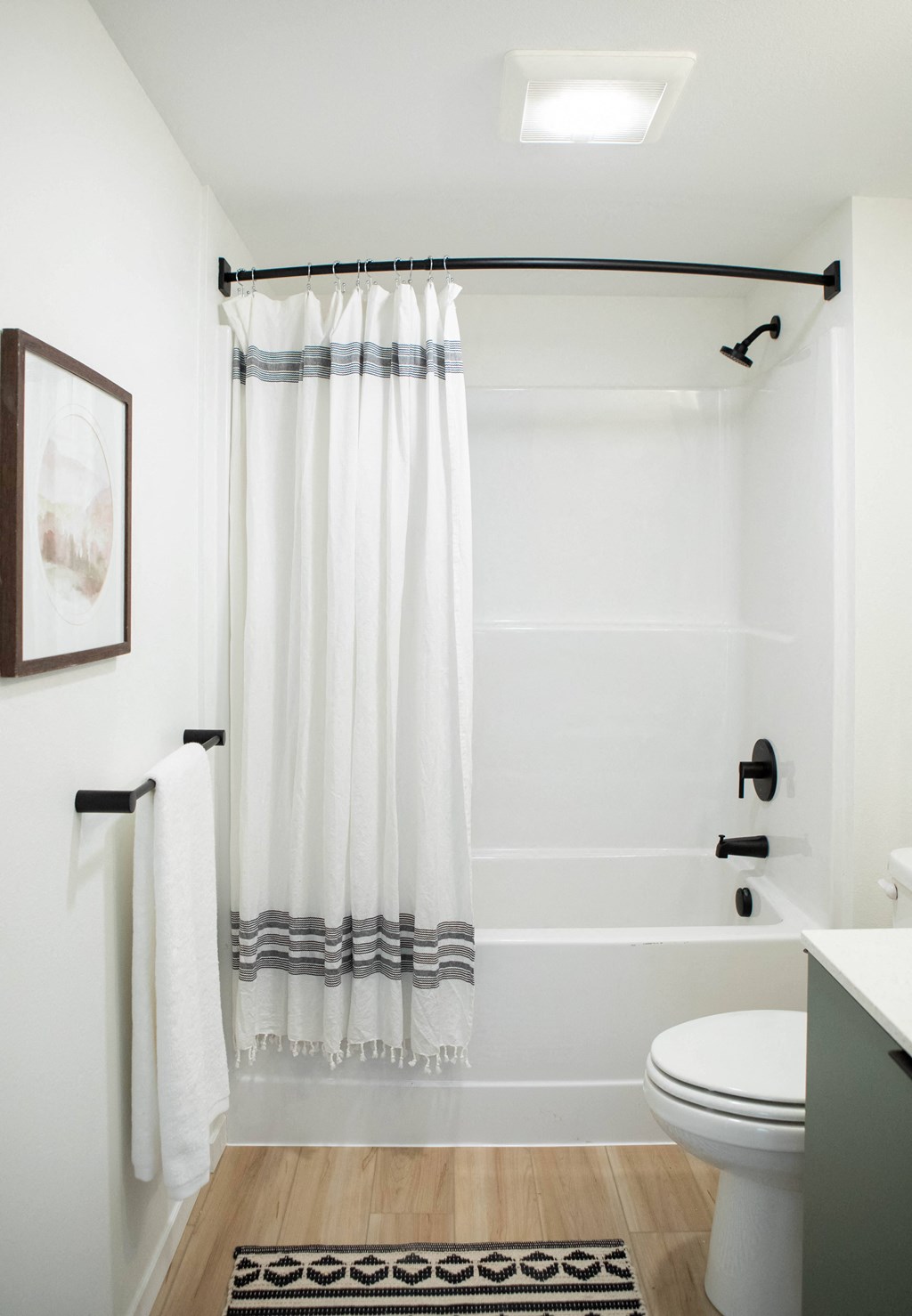 A white bathroom with a towel rack and a white toilet.