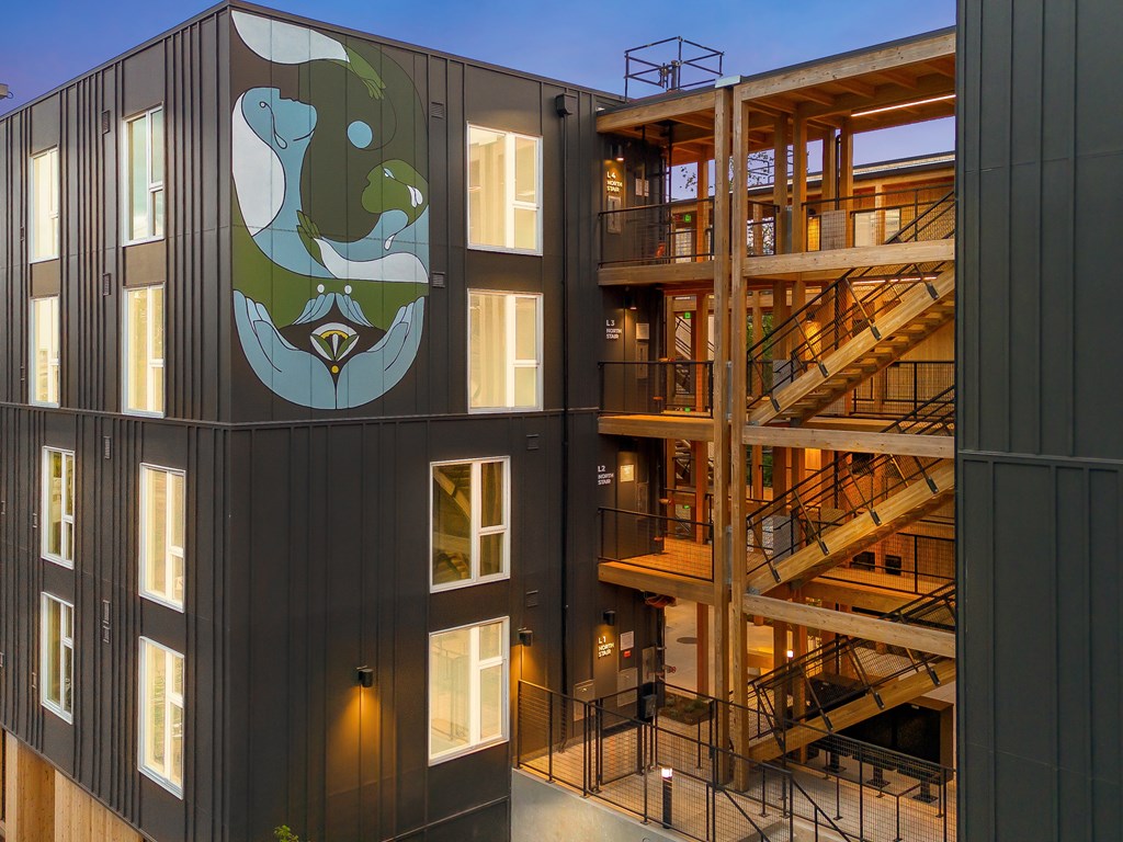 A modern building with a staircase and a mural on the side.