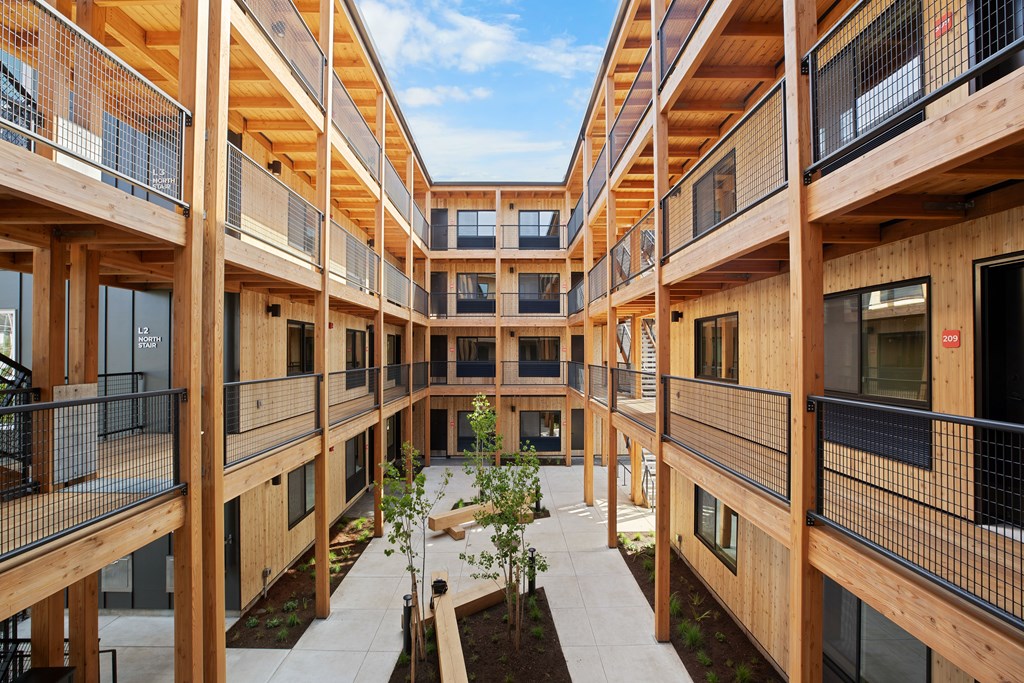 A courtyard surrounded by balconies with a tree in the center.